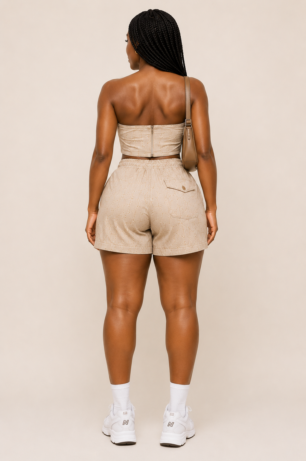 Woman wearing a beige romper on a plain background